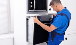 un tecnico controlla la parte sotto di un forno